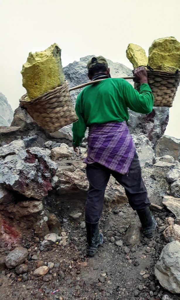 Sulphur miner carrying heavy baskets of sulphur at Ijen Crater, Banyuwangi, East Java.