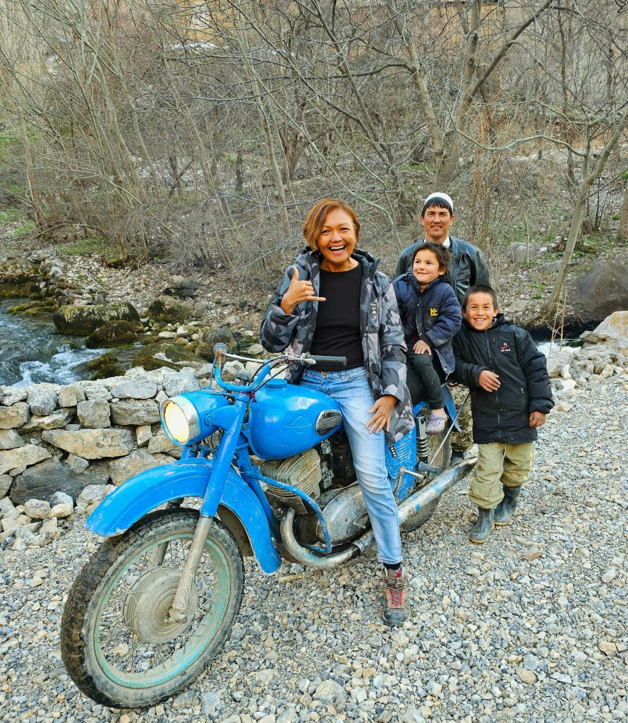 Travel writeron a bike with local villagers in a remote Tajikistan mountain valley