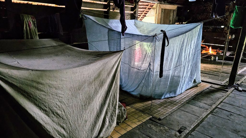 Mosquito net inside the Mentawai uma, showing the simple sleeping area used by the family.