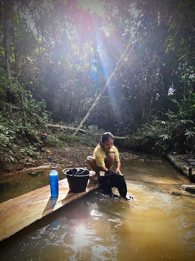Mentawai lady washing laundry at the river, showing the simplicity of traditional Mentawai life.