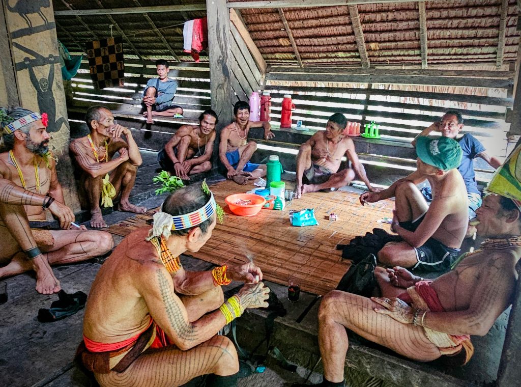 Mentawai shamans and local villagers hanging out together inside the uma community space.