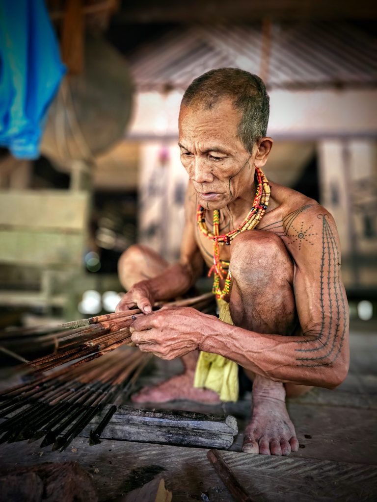 Mentawai shaman preparing traditional poison for hunting arrows using forest plants in Siberut.