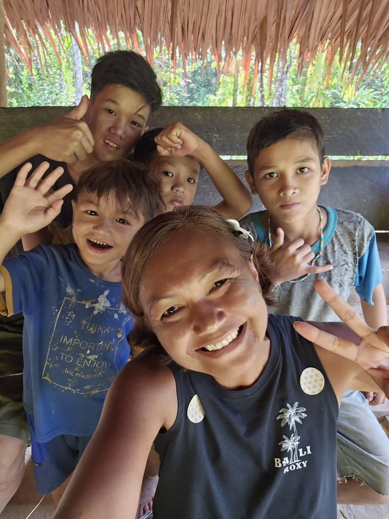 Shannim with the Mentawai children in the Siberut jungle, sharing a moment of connection with the community.
