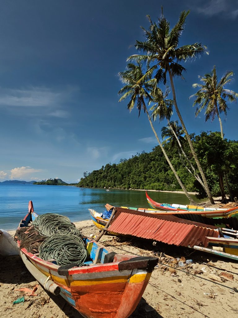 Traditional fishing boats on the beach in Sungai Pinang village, West Sumatra - authentic coastal community life in Indonesia