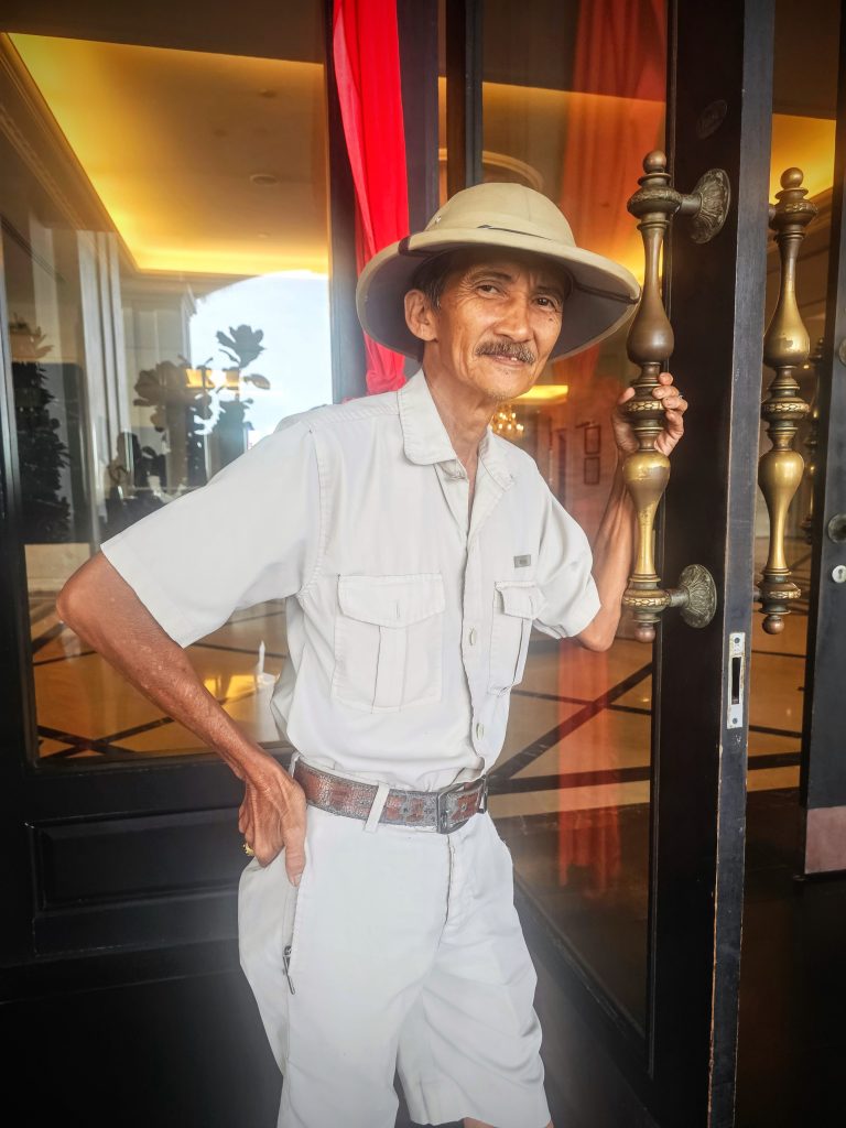 Pakcik Ezzat, a long serving bellman at E&O Hotel Penang, welcoming guests with a warm smile