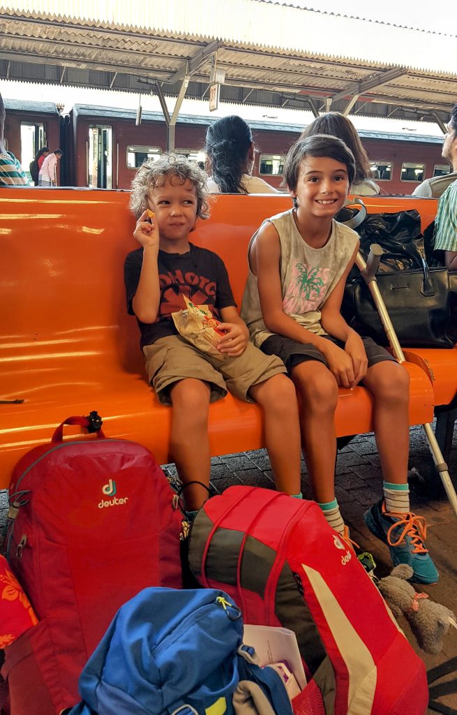 The kids happily sitting down at the train station in Sri Lanka
