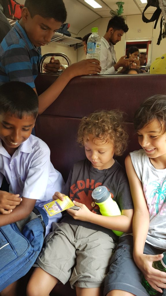 Children with locals on the train in Sri Lanka