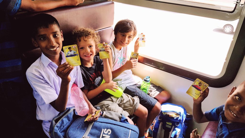 Children travelling light on a crowded train in Sri Lanka sharing a moment with local families