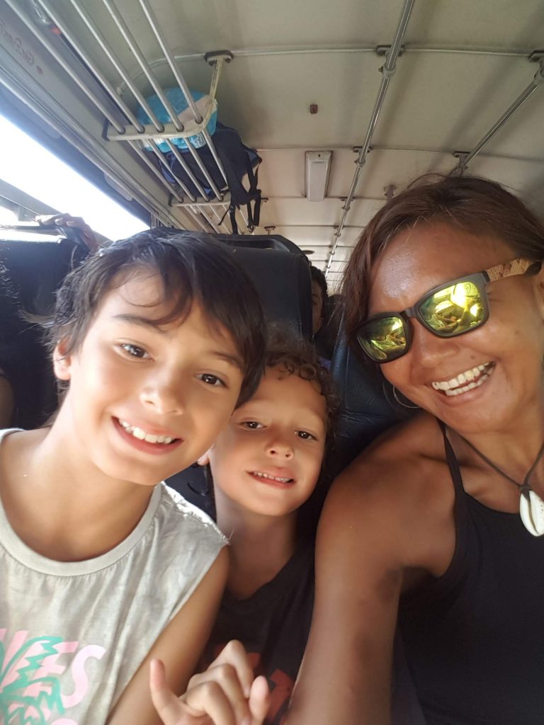 Mother and her two sons with rucksacks travelling light on a local bus in Sri Lanka