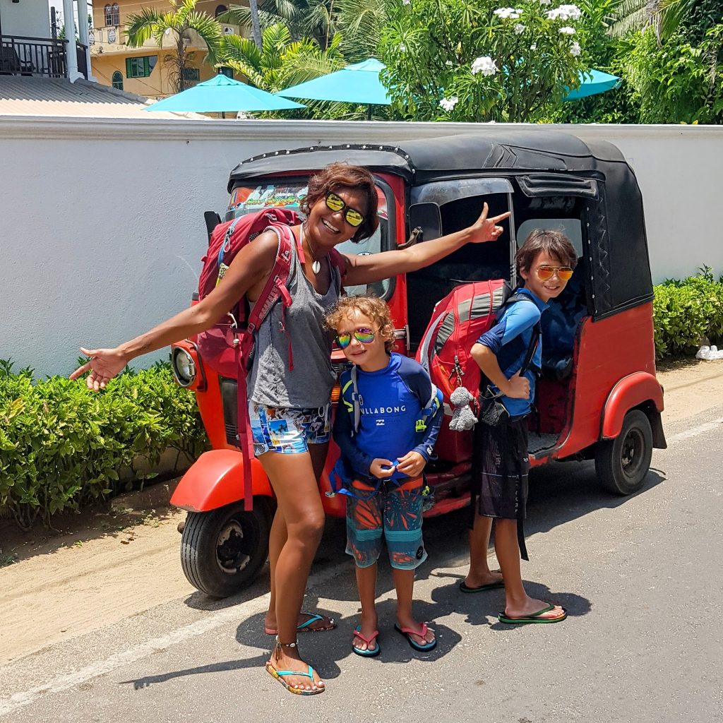Shannim the writer and her two sons with backpacks standing in front of a tuk tuk in Sri Lanka while travelling light as a family