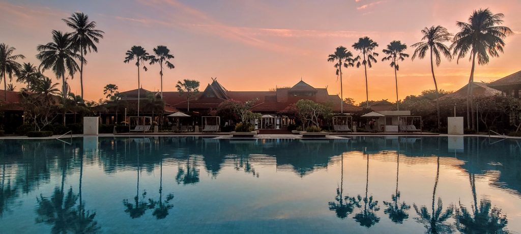Pelangi Beach Resort & Spa Langkawi - pool at sunrise with palm trees and morning sky reflections