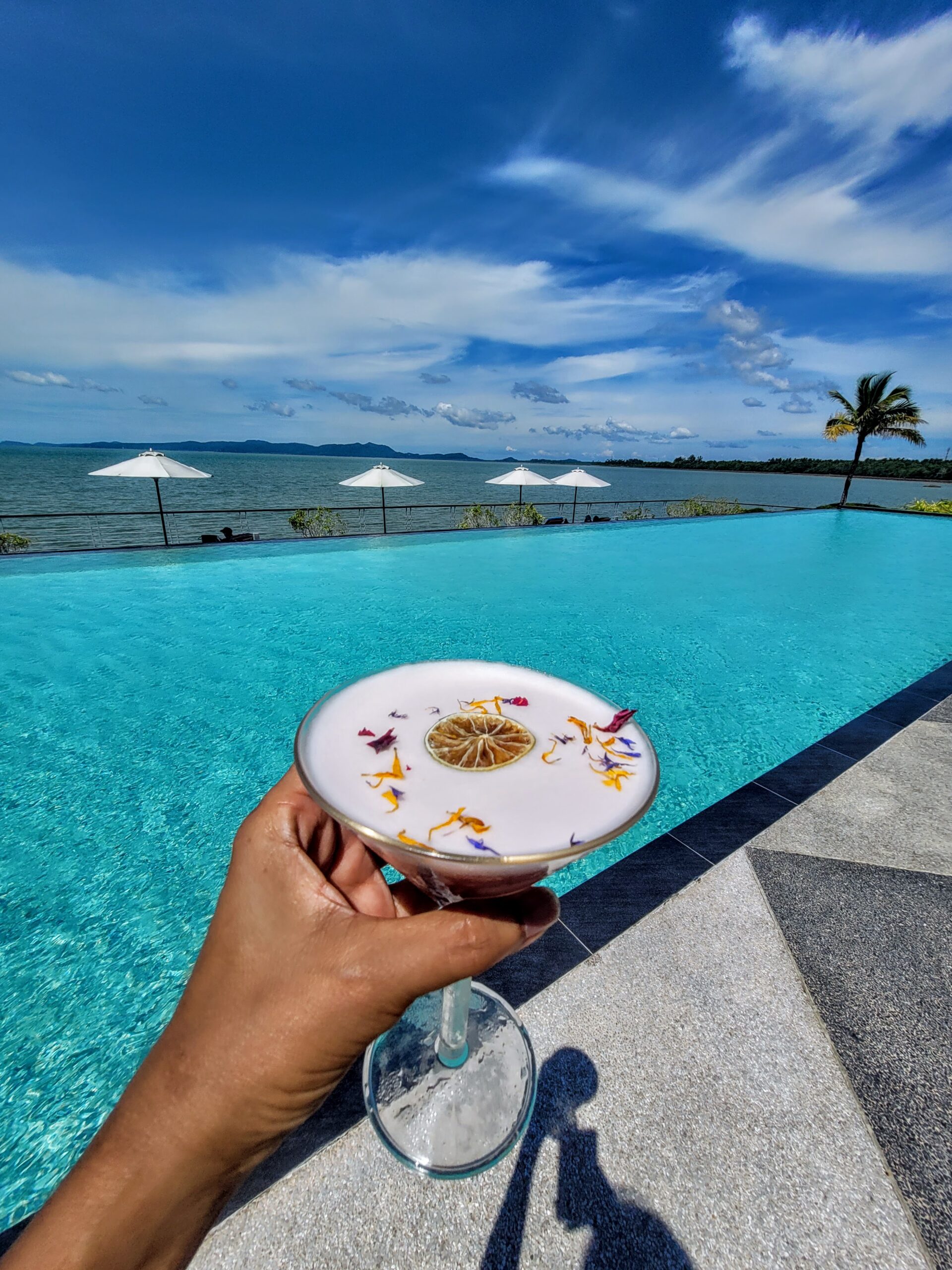Colourful signature cocktail served beside the infinity pool at Cove 55 boutique resort, Sarawak