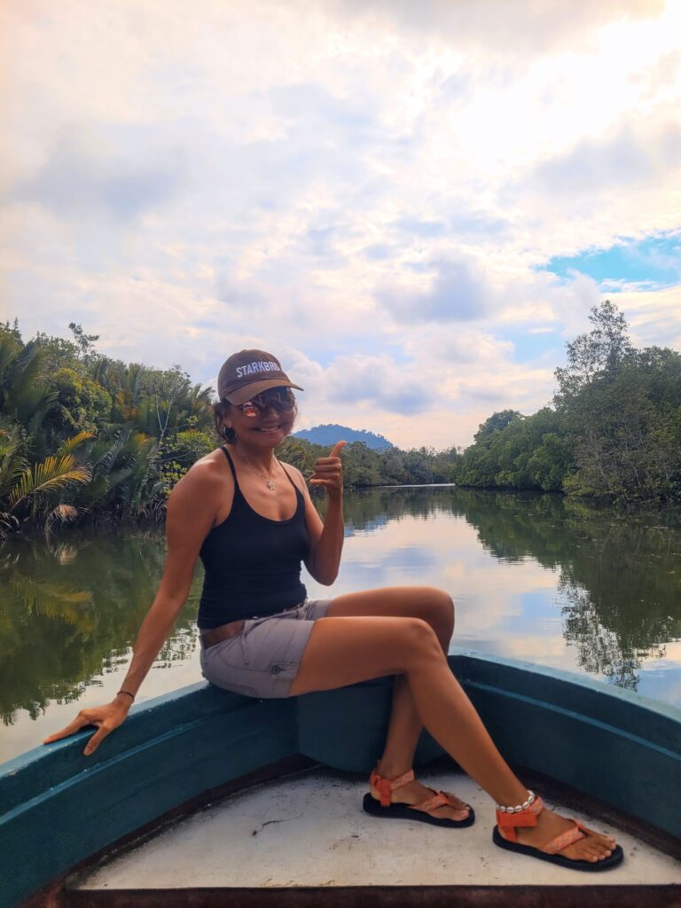 Travel writer on a boat cruising through the mangroves of the Santubong Wetlands, Sarawak