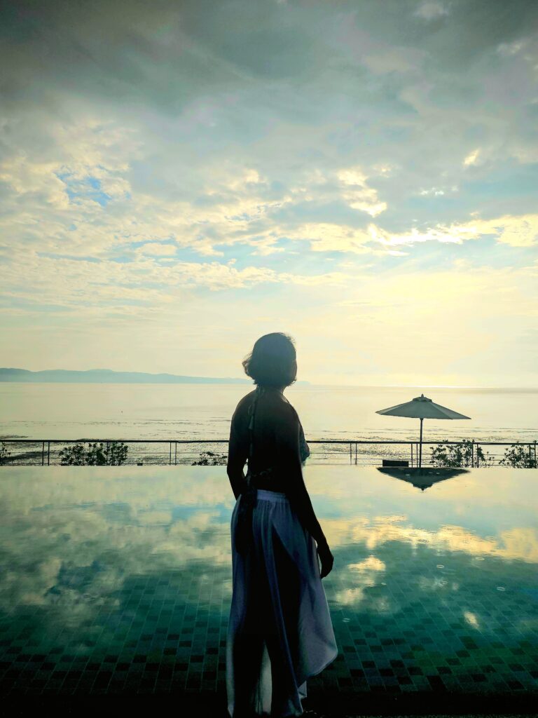 Travel writer by the infinity pool at sunrise at Cove 55 boutique resort in Santubong, Sarawak